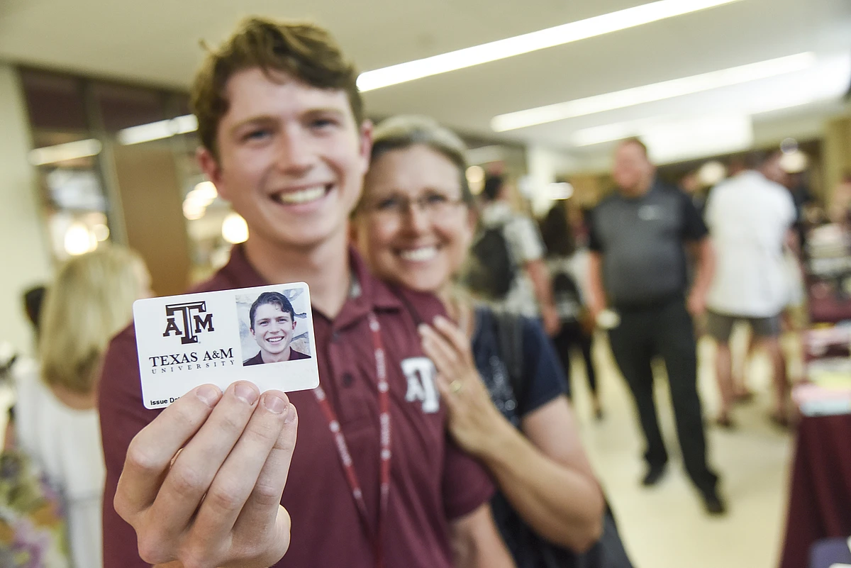 a student holding up their new aggie ID