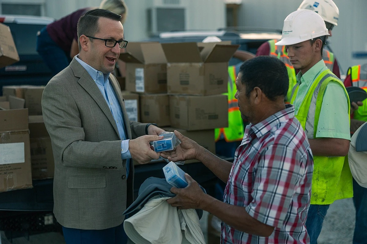 Nate Sharp, dean of the Mays Business School at Texas A&M University, presenting donated cooling towels and other supplies to campus construction workers.