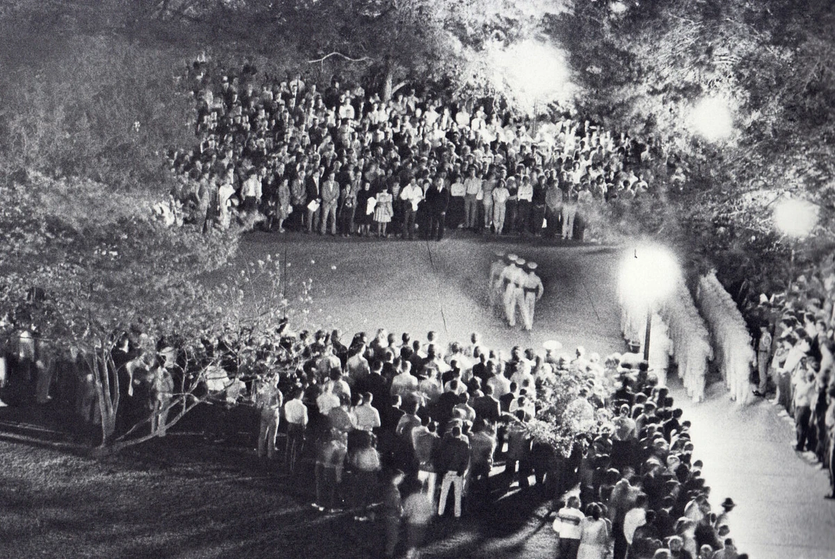 Unusual lighting conditions made this 1984 photo of Silver Taps possible. ‘They were doing some construction on the Academic Building at the time, so it wasn’t completely dark as it traditionally is. Without that, it would have been impossible to get this image,’ said former Battalion photographer Peter Rocha ’85. For the Ross Volunteers, he said, ‘The stop-start style of marching they do also made it possible. Otherwise, they would have been a blur.’