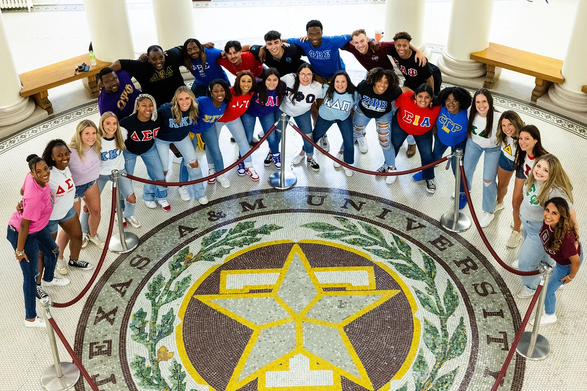 A group of Texas A&M Greek students around a seal. 