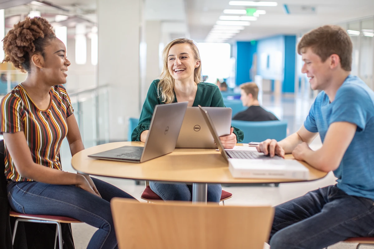 Three students talking at a table