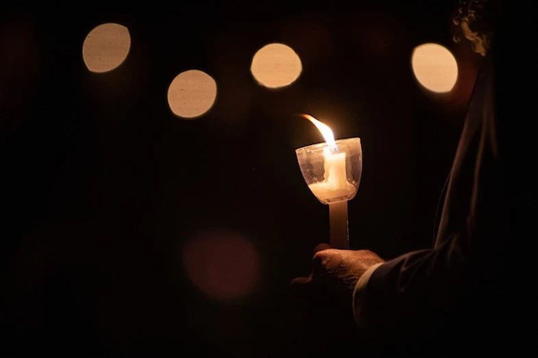 A photo of a candle that is lit being held at Aggie Muster 