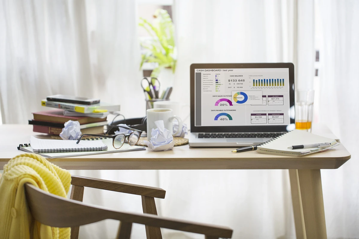An at home workspace with a desk and laptop